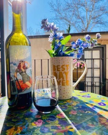 Wine glass and blue flowers on outdoor patio