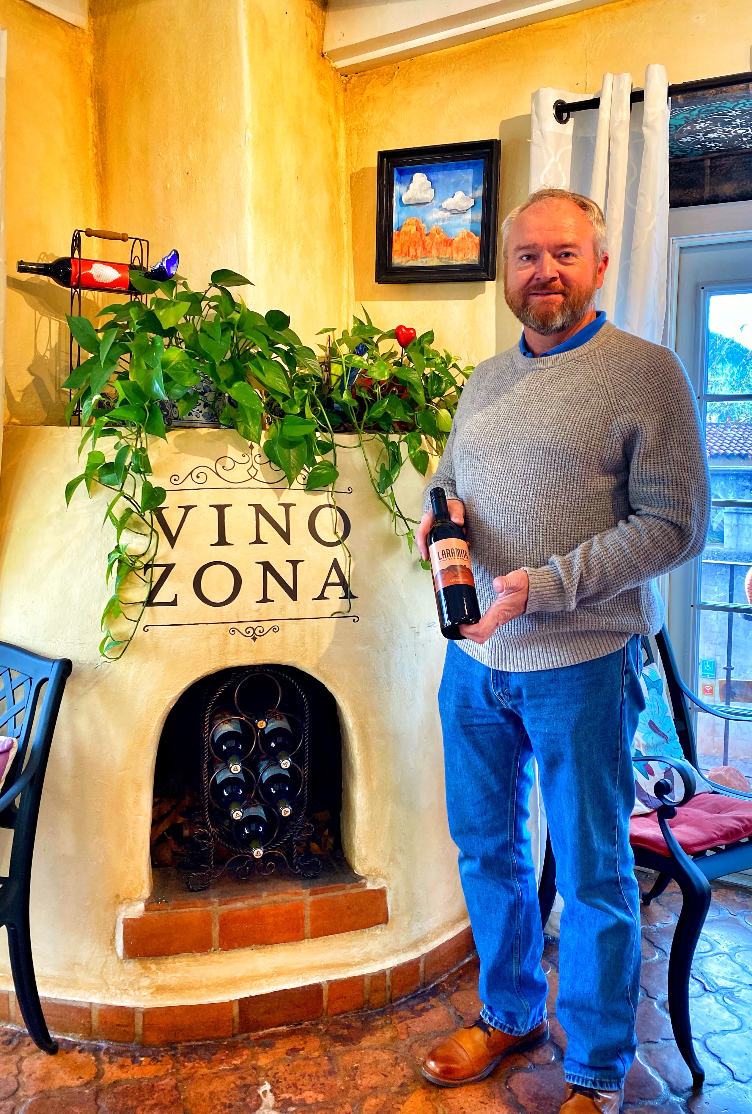 Man holding Laramita wine at Vino Zona fireplace