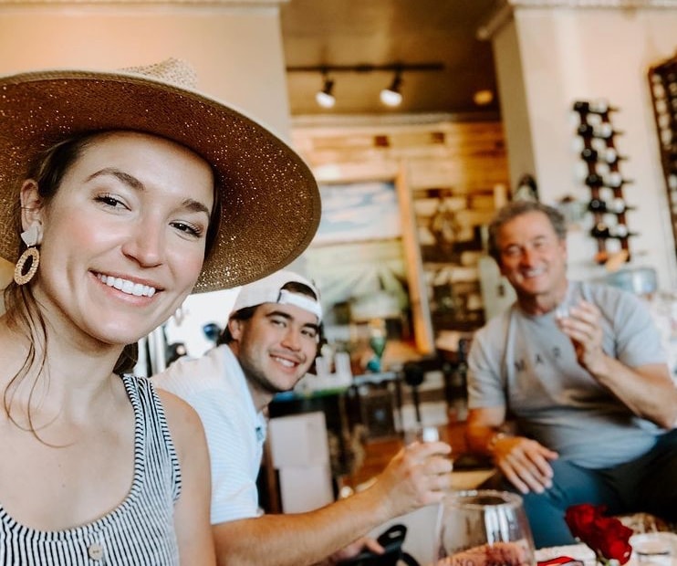 Family of three smiling at Vino Zona tasting room