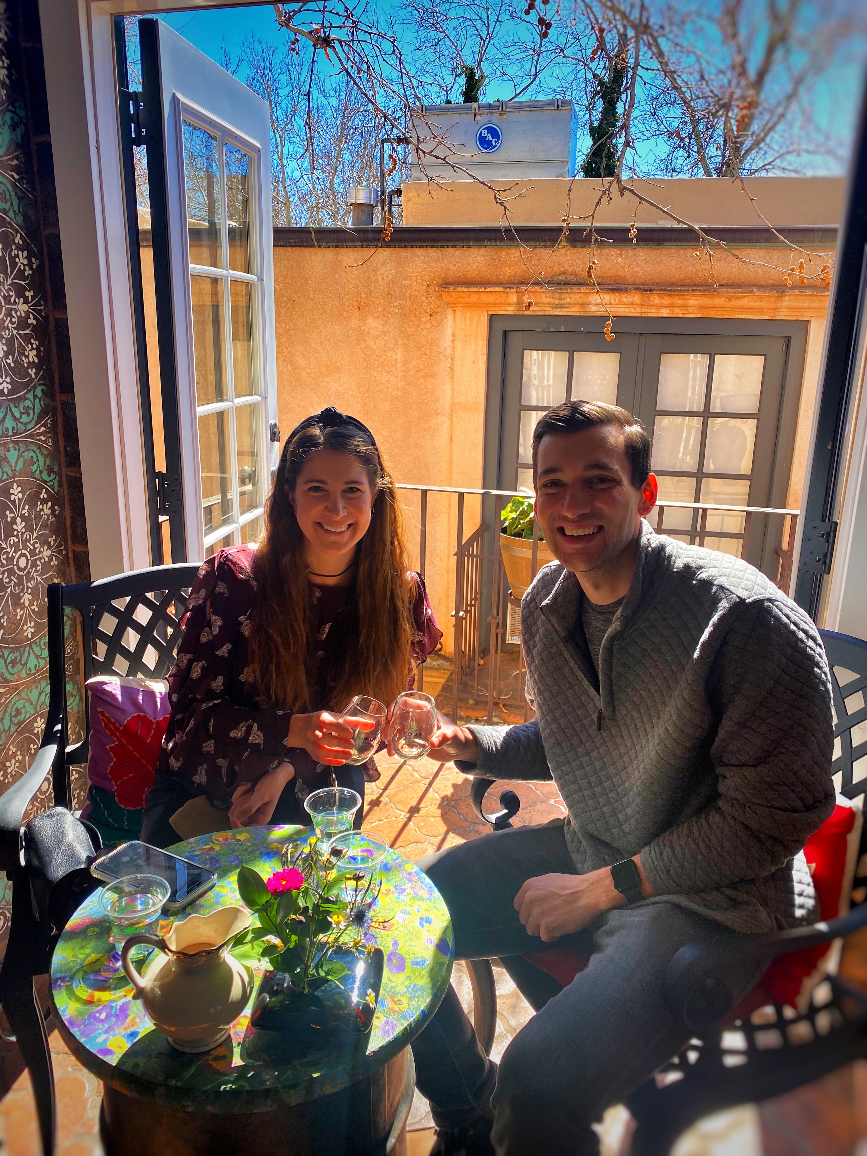 Couple toasting wine on sunny patio at Vino Zona